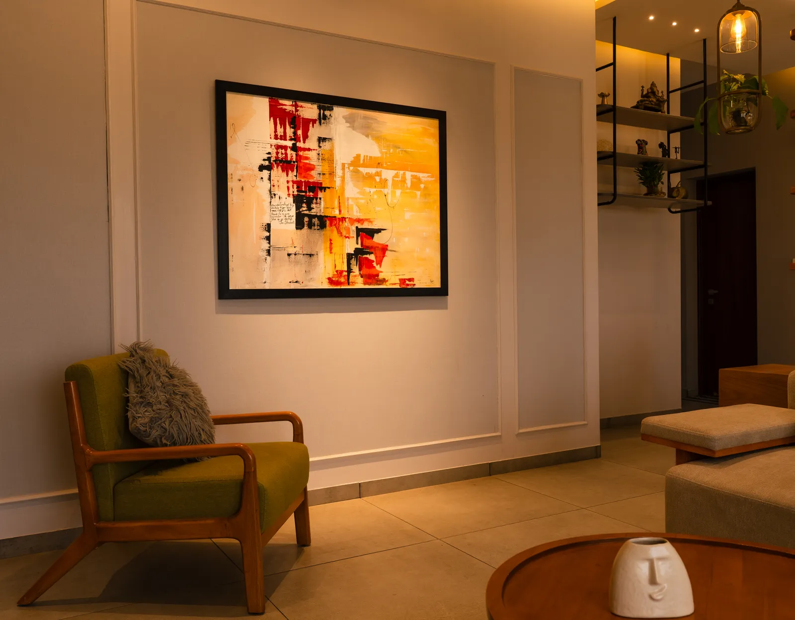 Green accent armchair beneath a red abstract painting — Amlan's Residence